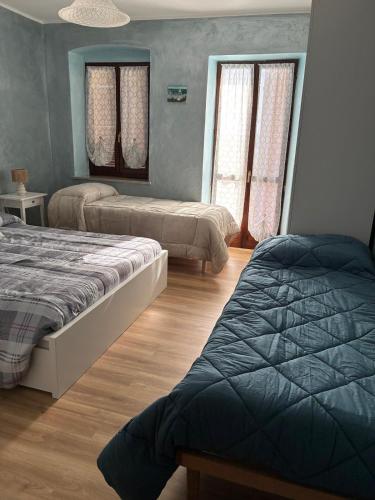 a bedroom with two beds and two windows at Il Casale Del Roero in Canale