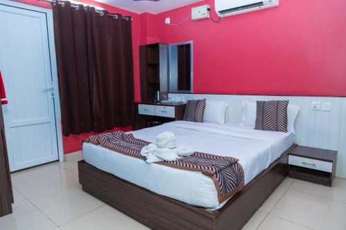 a bedroom with a large bed with a red wall at Hotel Royal Inn in Nawākot