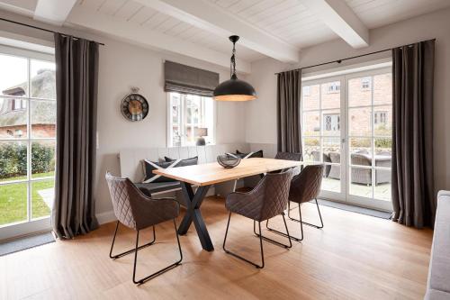 a dining room with a wooden table and chairs at Reethaus Nordgold in Oldsum