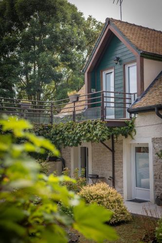 a house with a balcony on the side of it at L'instant Beaun'heur in Merceuil