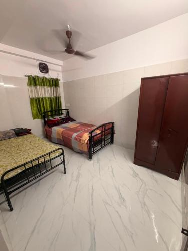 a room with two beds and a ceiling at Pushpa Di Ghar in Kolkata