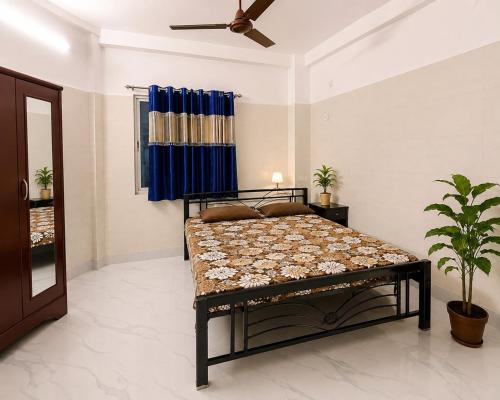a bedroom with a bed and a ceiling fan at Pushpa Di Ghar in Kolkata