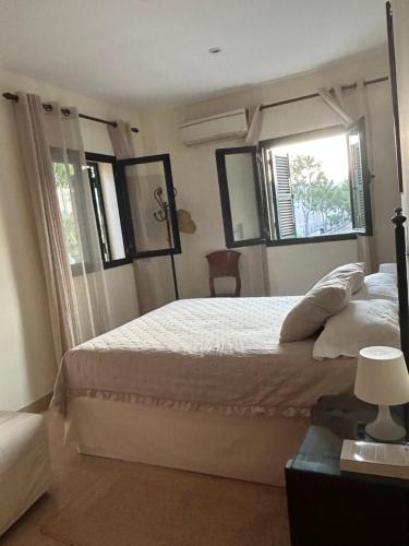 a bedroom with a large white bed with a window at Tramuntana & Beach in Pollença