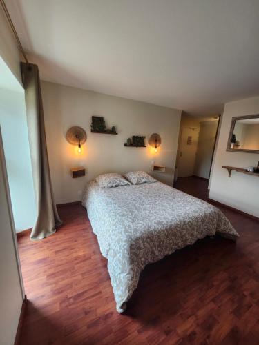 a bedroom with a bed and two lights on the wall at Douglas in Colleville-sur-Mer