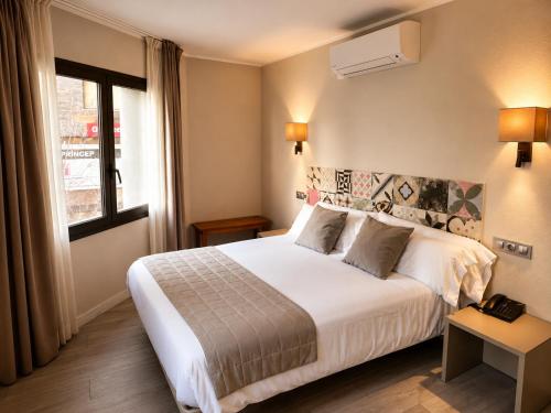 a hotel room with a bed and a window at Tudel in Andorra la Vella