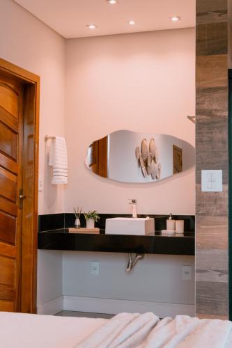 a bathroom with a sink and a mirror at Chalé Refúgio Fegama in Passa Quatro