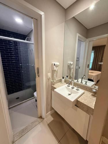 a bathroom with a sink and a mirror at Unique (Ex-Estanconfor) veja o mar do apto 703 in Santos