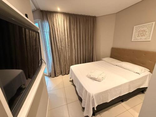 a bedroom with a bed and a large window at Unique (Ex-Estanconfor) veja o mar do apto 703 in Santos