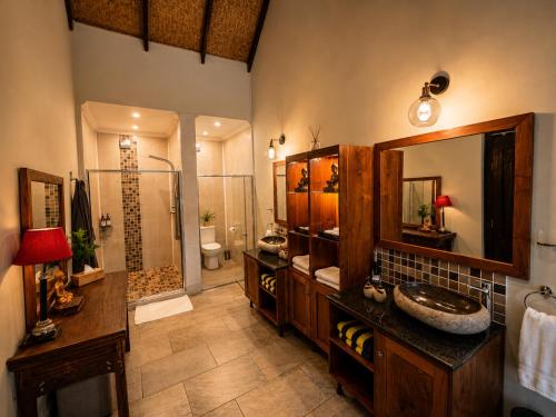 a large bathroom with a sink and a shower at The Zarafa in Hazyview