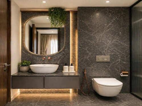 a bathroom with a sink and a toilet and a mirror at CHINDU HOUSE Inn in Chennai