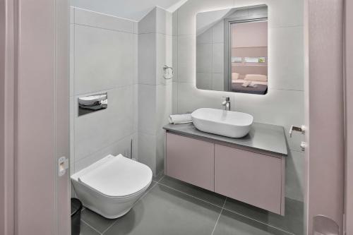 a white bathroom with a sink and a toilet at Sun & Moon Luxury - Celeste Villa in Ayia Napa