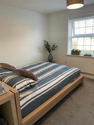 a large bed in a room with a window at Rushes View Homestay in Market Harborough