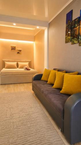 a living room with a couch and a bed at Кошкарбаева 58 in Kokshetau