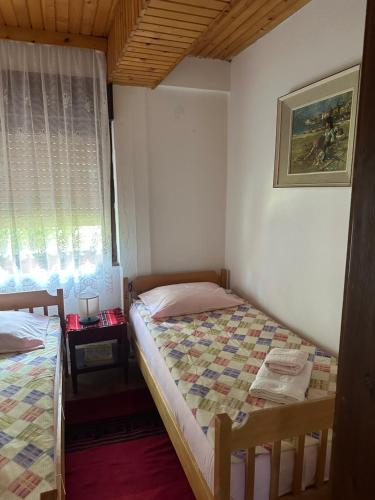 a bedroom with two beds and a window at Vila Popovski in Ljubaništa