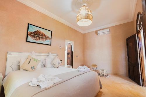 a bedroom with a large white bed with towels on it at Palais Zoya in Marrakesh