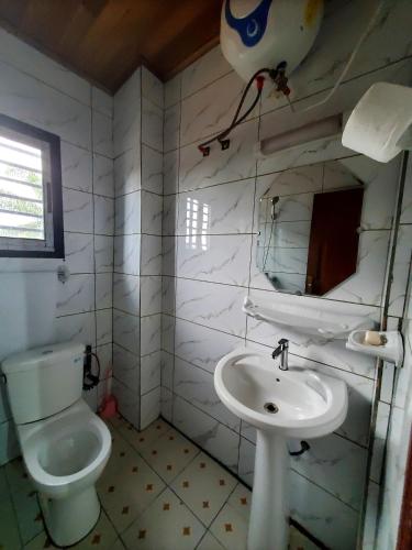 a bathroom with a toilet and a sink at At Home Bertoua in Bertoua