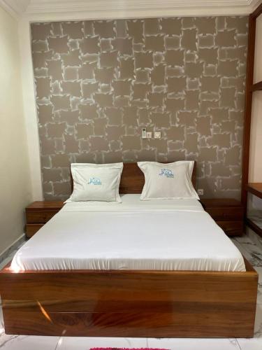 a bed with two pillows on it in a room at At Home Bertoua in Bertoua