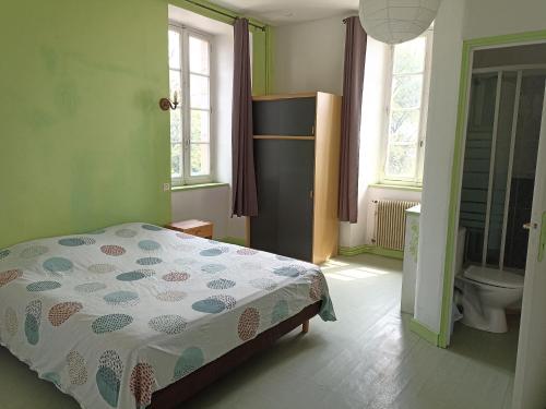 a bedroom with a bed and a bathroom with a toilet at Chambres d'Hôtes Le Clos Ambels in Ambialet