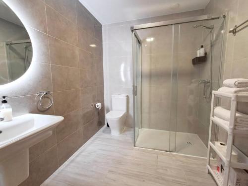 a bathroom with a shower and a toilet and a sink at Apartamentos PORTA NOVA 2 in Lugo