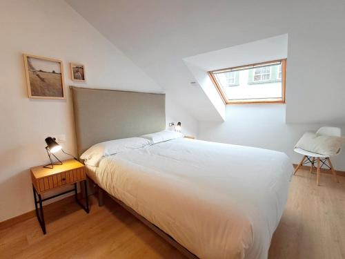 a bedroom with a large white bed and a window at Apartamentos PORTA NOVA 2 in Lugo