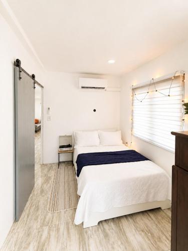 a white bedroom with a bed and a window at Finca Sol y Sal 