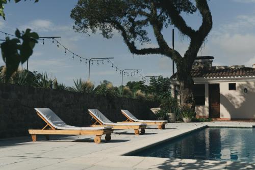 a row of lounge chairs next to a swimming pool at Rincon del Cerro I in San Lorenzo