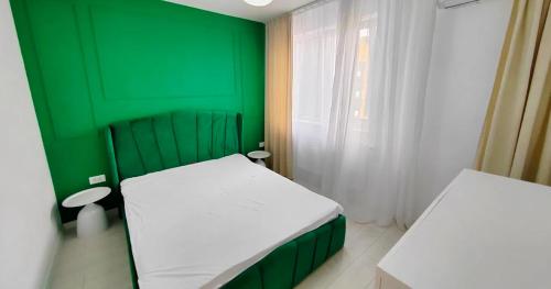 a green room with two beds and a window at Exclusive location in West Bay