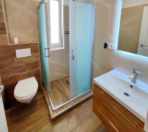 a bathroom with a shower and a toilet and a sink at Exclusive location in West Bay