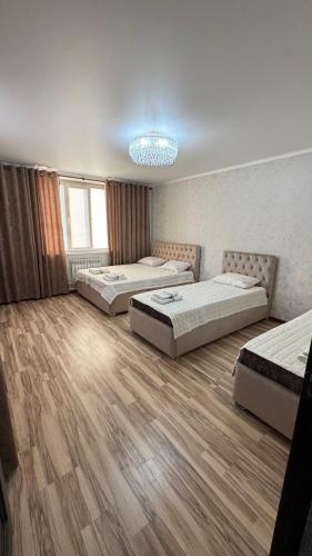 a bedroom with three beds and a chandelier at Rinat Guest House in Pokrovka