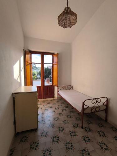 a bedroom with a bed and a table and a window at Villa Sunrise in Casteldaccia