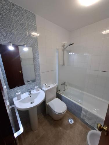 a bathroom with a toilet and a sink and a tub at Casa turística AZAHAR in Villablanca