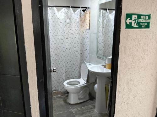 a bathroom with a toilet and a sink at Las Margaritas Cabaña in Chinchiná