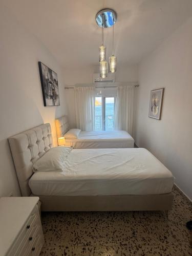 a bedroom with two beds and a window at VILLA BLANCA in Haraki