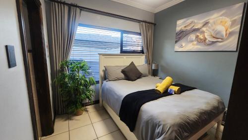 a small bedroom with a bed and a window at Topanga 17 in Uvongo Beach