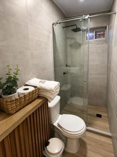 a bathroom with a toilet and a glass shower at Eco-Hotel Palma É Coco in San Andrés