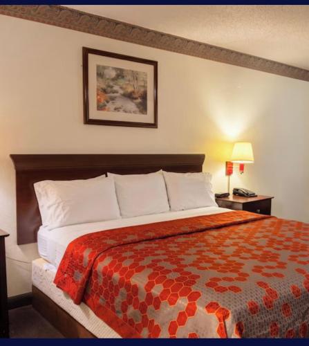 a bedroom with a large bed with a red blanket at EXECUTIVE INN & SUITES HIGHWAy US 59 in Lufkin