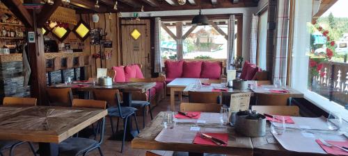 a restaurant with tables and chairs and pink seats at Le Taconet in Le Praz de Lys