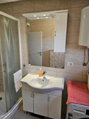 a bathroom with a sink and a mirror at Rooms Mario in Međugorje