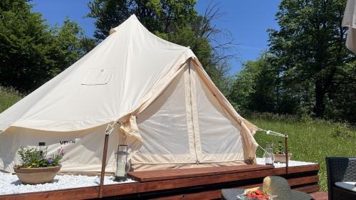 a white tent with a table in a field at Vrhnika hill in Vrhnika