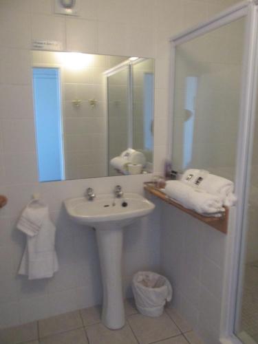 a white bathroom with a sink and a mirror at Casa Del Mar in Hermanus