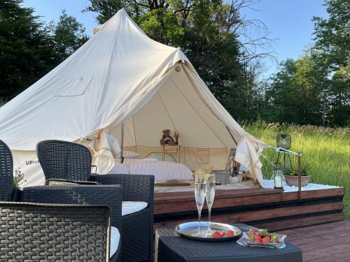 a white tent with a bed and a table at Vrhnika hill in Vrhnika
