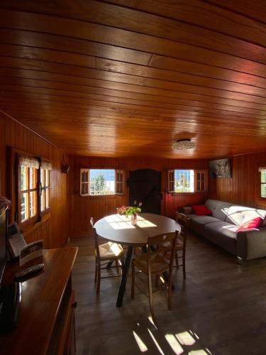 a living room with a table and a couch at Le Mazot in Veyrier-du-Lac