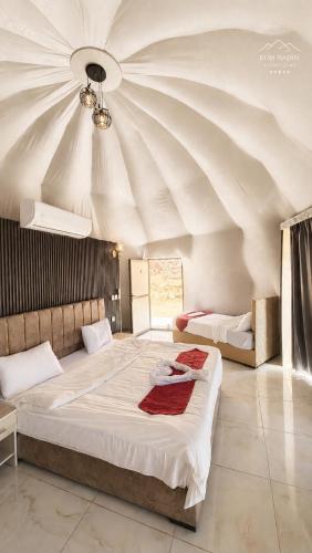 a bedroom with a large bed with a ceiling at RUM NADINE LUXURY CAMP & Bubbles Hotel in Wadi Rum