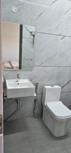 a bathroom with a sink and a toilet and a mirror at Cherry Bloom in Chikmagalūr