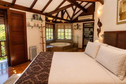 a bedroom with a large bed in a room at Chalé Guararema in Petrópolis