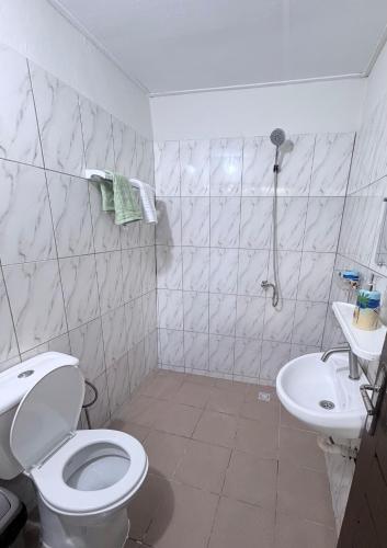 a white bathroom with a toilet and a sink at Studio Paisible Aéroport FHB in Abidjan