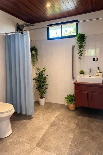 a bathroom with a shower and a toilet and a sink at Tardes Doradas in Quepos