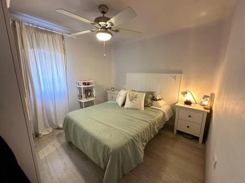 a bedroom with a bed and a ceiling fan at Apartamento próximo al palacio de congresos in Granada