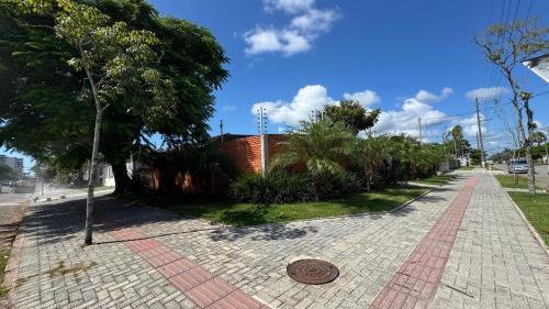 a sidewalk with a manhole in the middle of a street at Quarto Aconchego in Guaratuba