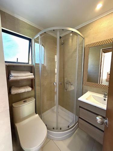 a bathroom with a shower and a toilet and a sink at Stellamar Apart Hotel in La Serena